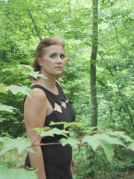 Frau im schwarzen Kleid im Wald